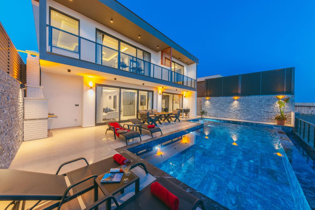 Luxury modern villa with illuminated pool at dusk