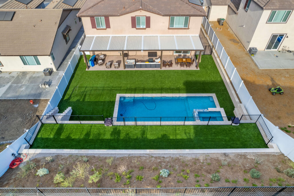 Aerial view of backyard pool and spa with patio seating