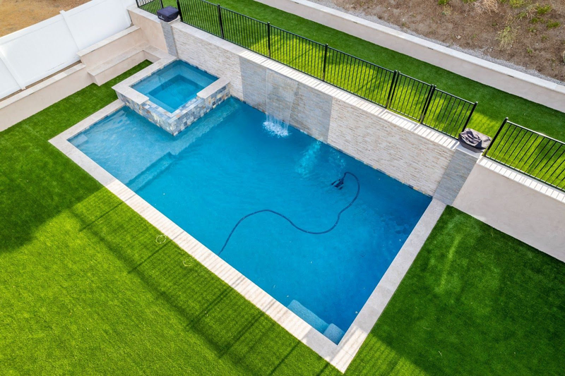 Modern California custom pool with spa and stone wall