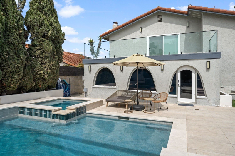 Modern pool with spa and patio seating in backyard
