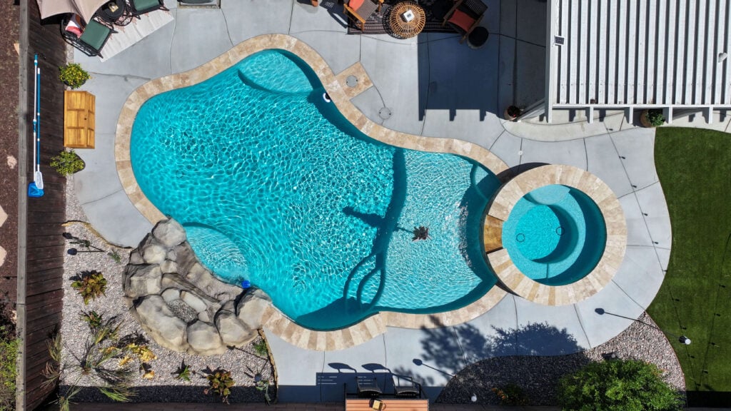 Aerial view of freeform pool with spa and rock feature
