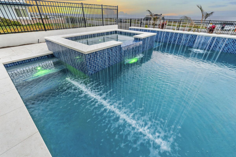 California custom pool with raised spa and waterfall feature