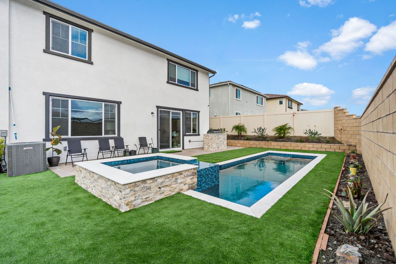 California custom pool with raised spa and backyard lawn