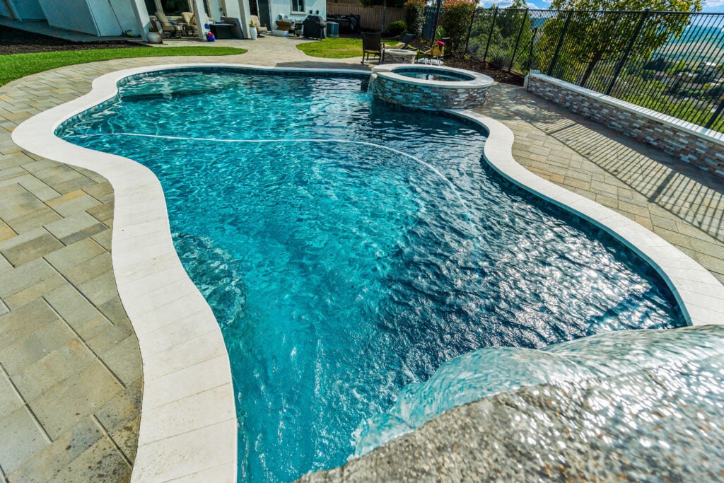 Freeform pool with spa and stone waterfall feature
